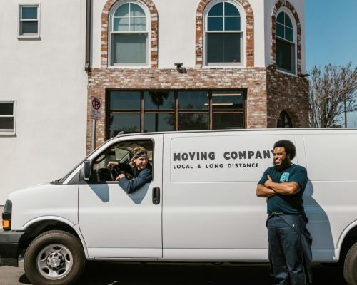 Moving company team with van parked outside building, ready for service.